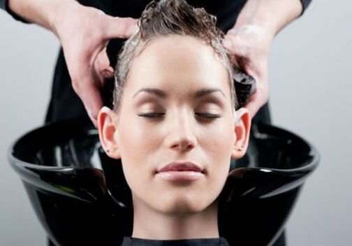 Sie tragen das Produkt auf ein Mädchen auf, während es sich die Haare bürstet